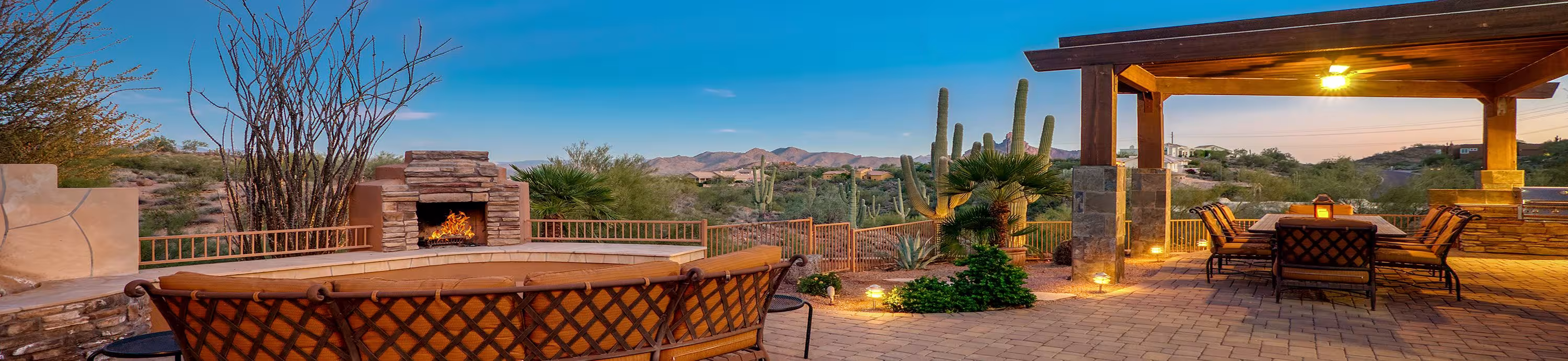 Scenic outdoor patio in Arizona with a fireplace, desert landscape, cacti, and mountain views, perfect for relaxing after golf.